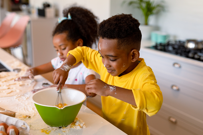 Happy siblings baking in kitchen