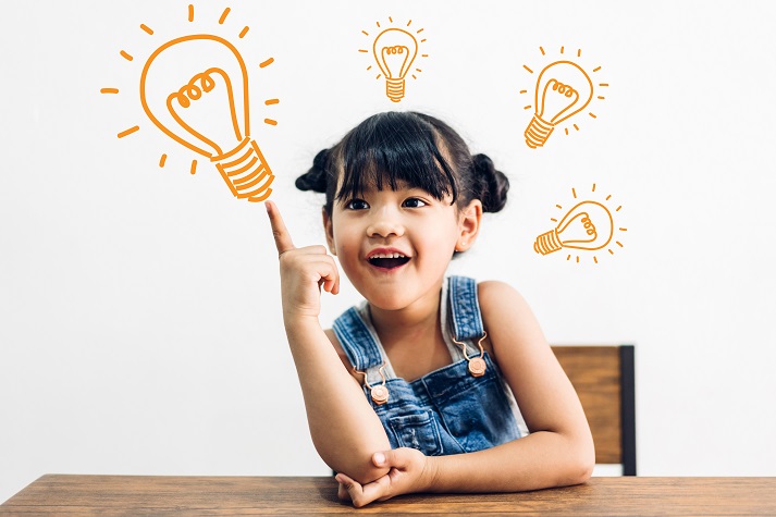 Portrait of happy smiling student girl having fun sit on table and looking at education thinking with lightbulb brainstorming