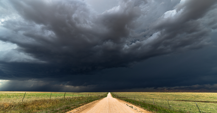 Dirt road with dark storm clouds