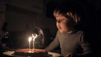 boy trying to blow out trick birthday candles