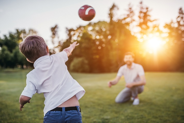 throwing a football Dad with son playing American football