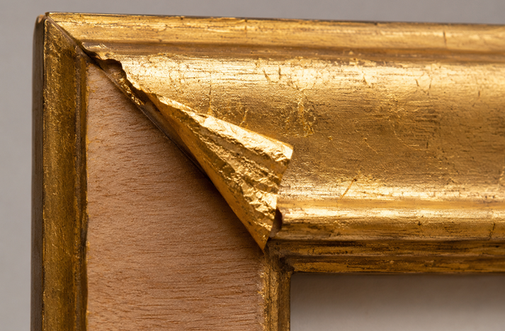Aged gilded frame corner with peeling gold
