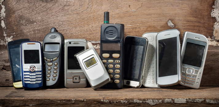 Old and obsolete mobile phone or cell phones on space of old wood background