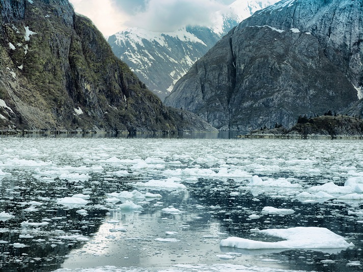melting ice Scenic coastal landscape with steep glacially polished cliffs and floating ice at Tracy Arm Fjord, Alaska