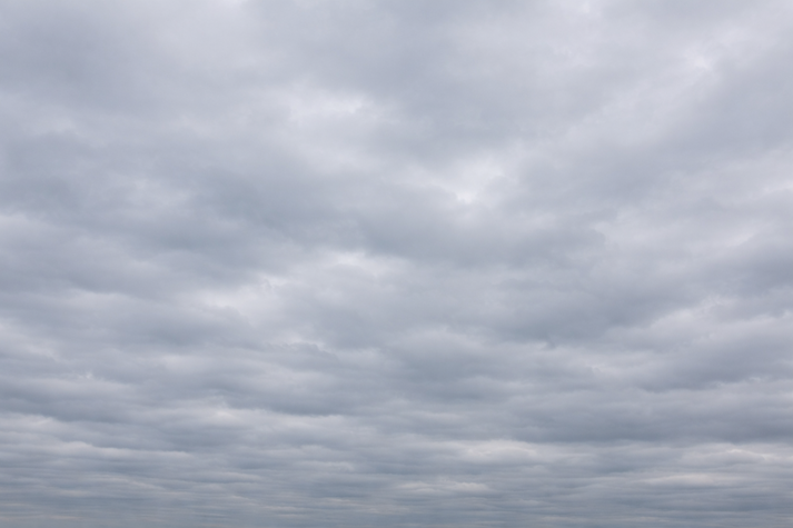 A full gray sky covered with flat, low clouds stretching across the horizon