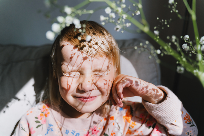Beautiful little girl smiling and squinting in sunlight